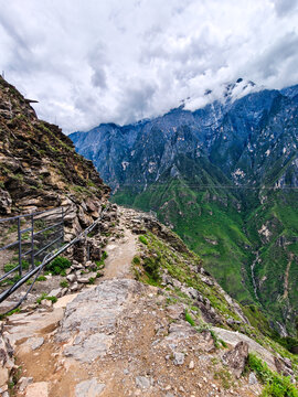 Cliffside mountain trail overlooking a green valley