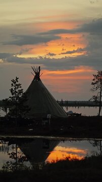 Tipi Silhouette by Lake at Sunset with Reflection