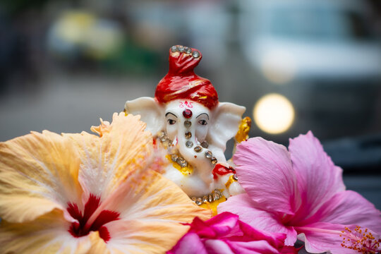 Lord Ganesha statue with hibiscus flowers celebrating religion
