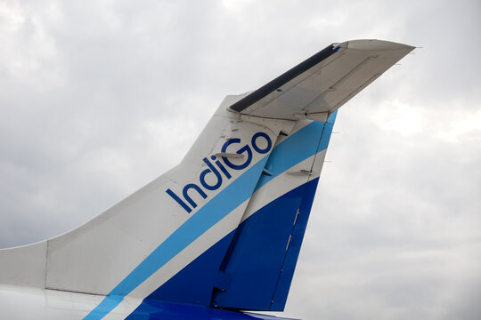 IndiGo airplane tail fin with logo against cloudy sky