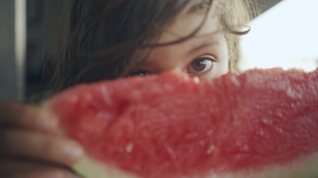 Extreme close-up of a child biting into juicy watermelon