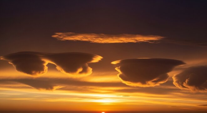 Stunning Mammatus Clouds Glowing with Golden Sunlight at Dusk Against a Deep Purple Sky