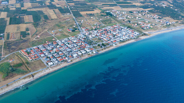 Greek coastal village beside turquoise sea at Paralia Dionisiou