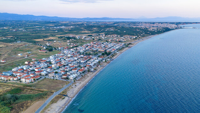 Coastal village homes set between blue sea and rural farmland