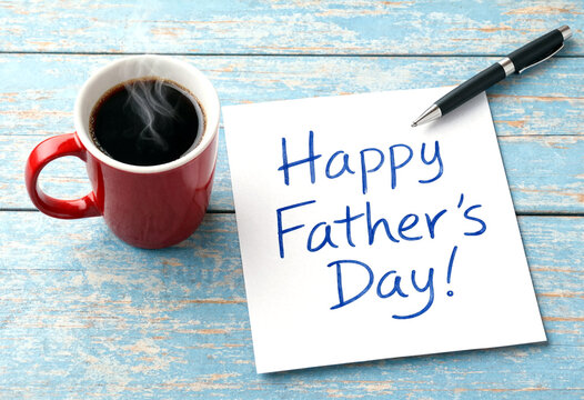 Happy fathers day greeting card with steaming coffee mug and pen on wooden table