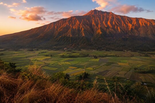 Terraced Farmland Valley Beneath Glowing Volcanic Mountain Ridge At Sunset