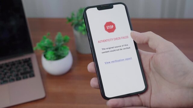 AI authenticity app displays a stop warning that the original source of the content cannot be verified on a handheld mobile device.