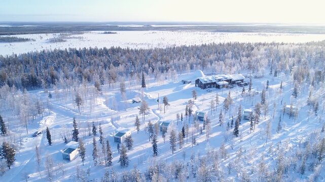 Aerial view of luxury glass igloos in snowy Finnish forest during winter.
