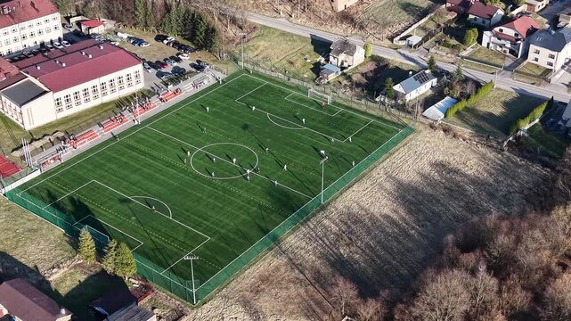 Aerial view of green football pitch near houses