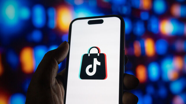 Tiktok shop logo displayed on mobile phone screen with vibrant colorful bokeh light background art.