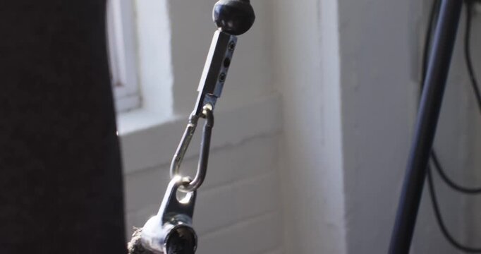 Man reaching, grasping braided rope handles and pulling for gym workout, copy space