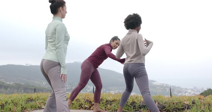Female coach with two female students cueing moves walking between mats aligning lunges on deck