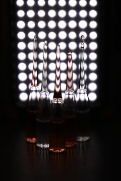 Dramatic Lighting on Glass Vials Creating Striking Reflections and Shadows