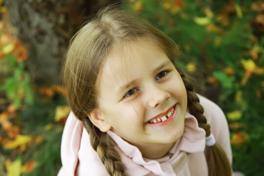 Smiling Child with Braids Enjoying Autumn Outdoors in Nature