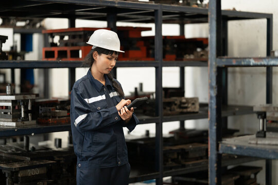 Industrial inspector woman examining metal parts in warehouse