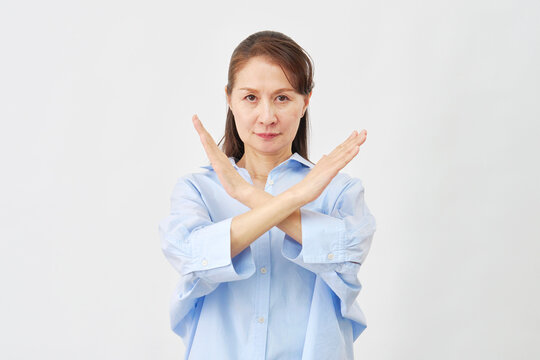 白背景でバツサインをする女性