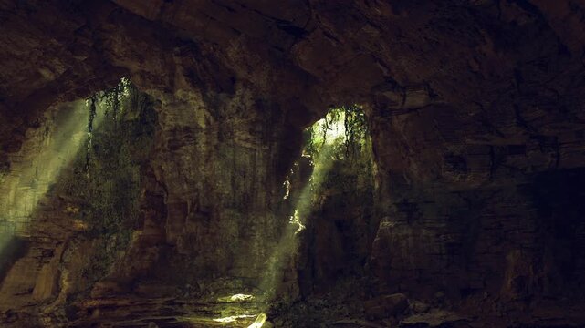 Two light shafts piercing cavern darkness, dusty beams illuminate rocky ledges and damp floor, dramatic contrast and textured stone form cinematic subterranean