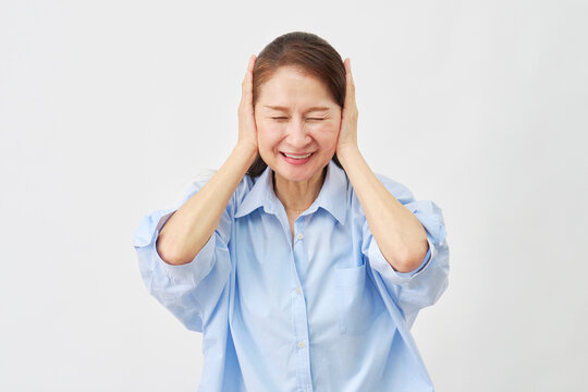 白背景で耳を塞ぐ高齢女性