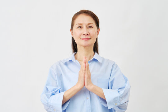 白背景で祈る高齢女性
