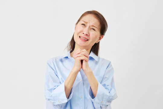 白背景で懇願する高齢女性