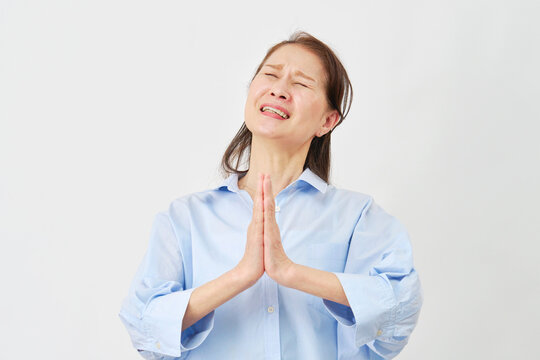 白背景で懇願する高齢女性