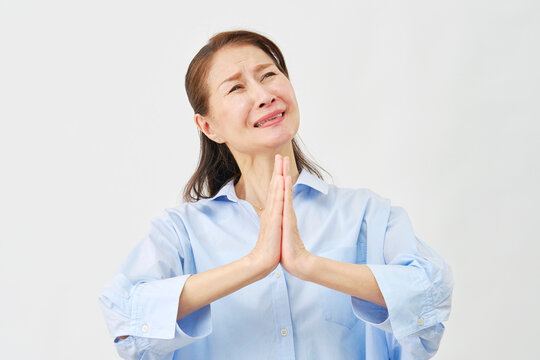 白背景で懇願する高齢女性