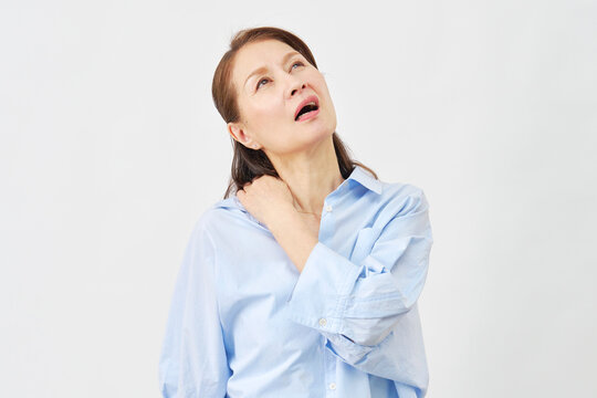 白背景で肩の痛みに悩む女性