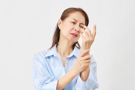 白背景で手の痛みに悩む女性