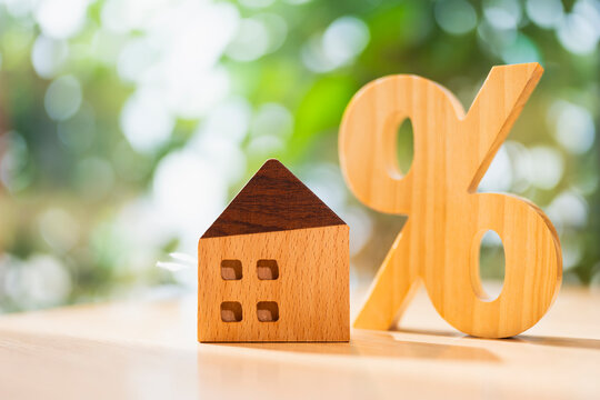Real estate house model with percent sign symbol. Home loan interest rate, property mortgage discount, house price promotion concept.
