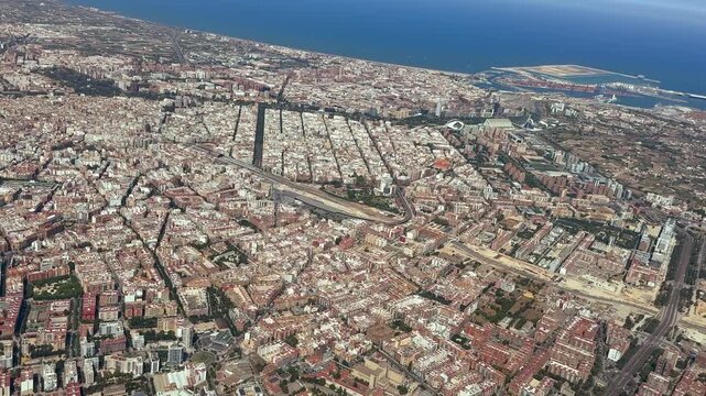 Spinning aerial panoramic view of Valencia city and coast taken at 2000m high from an airplane cockpit flying at 2000m high, with a view of city center, coast, harbor and Malvarrosa beach.