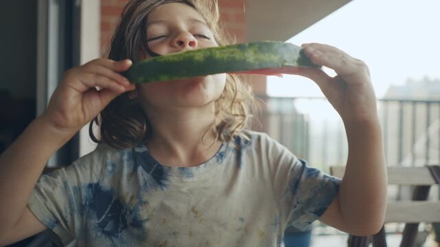 Playful child holding up a finished watermelon rind