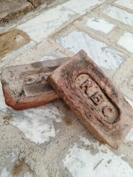 Vintage Red Clay Bricks with KBC Stamp on Stone Floor in India