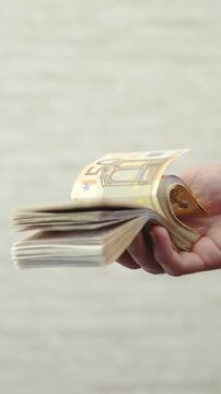 One hand flipping pack of money banknotes in slow motion