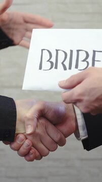 Handshake and giving the bribe envelope in slow motion