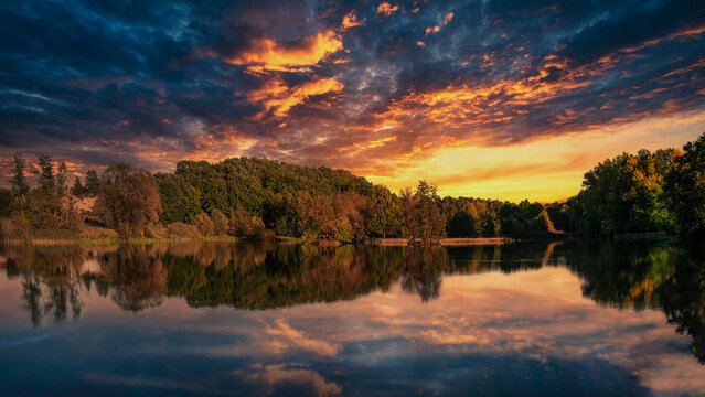 Vibrant fiery sunset reflecting on a calm lake