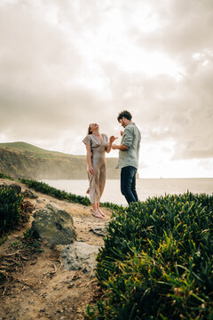 Young couple laughing hysterically on a cliffside path