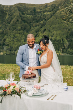 Happy newlywed couple cutting their wedding cake together