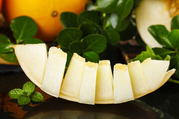 Fresh Sliced Honeydew Melon Wedges with Mint Leaves - Sweet Yellow Summer Fruit © DinhThi