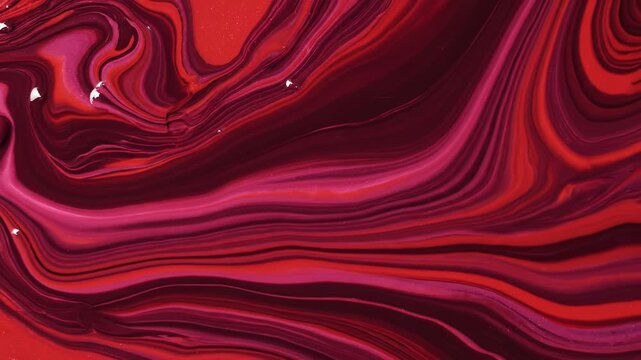 Abstract swirling liquid texture with flowing red and magenta marble patterns creating dynamic wavy motion and artistic fluid marble effect in a high quality macro composition