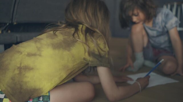Siblings drawing together on the living room floor