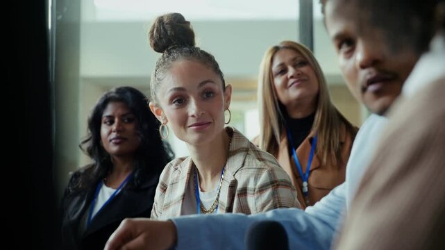 Attendees engage and listen carefully to a speaker at a professional conference or convention. The atmosphere is collaborative and focused, highlighting interaction and learning among participants.
