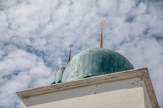 Mosque Green Dome with Crescent and Star Symbol Against Cloudy Sky.