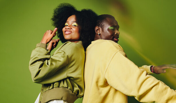 Back-to-back friends dance in the studio with stylish youthful confidence