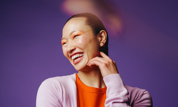 Happy woman laughing with joyful expression in a colorful studio portrait