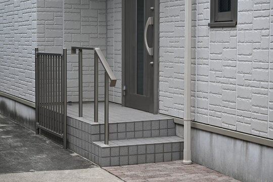 手すりと階段を備えた住宅の玄関アプローチ