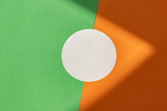 Geometric minimalism with white circle on green and orange background