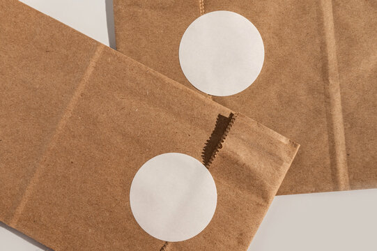 Brown paper packaging with round white stickers on seamless background