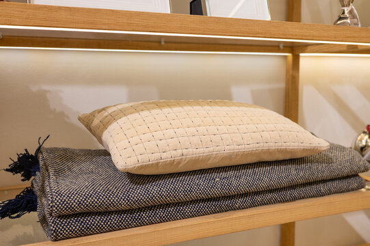Cozy shelf display: beige pillow on textured blanket