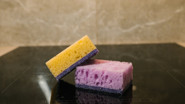 Colorful kitchen sponges on black countertop surface