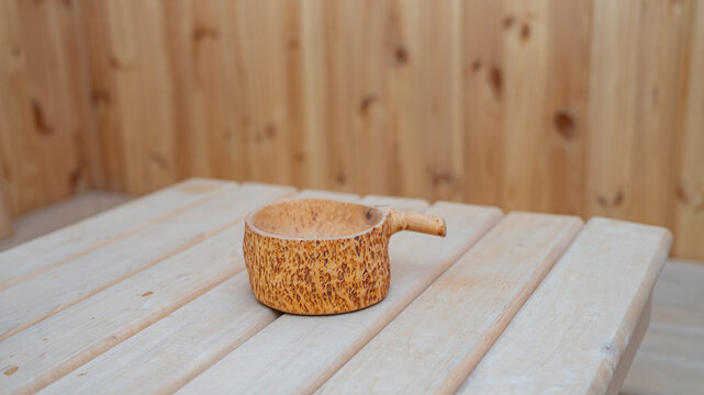 Rustic wooden cup on light wooden table with wooden background